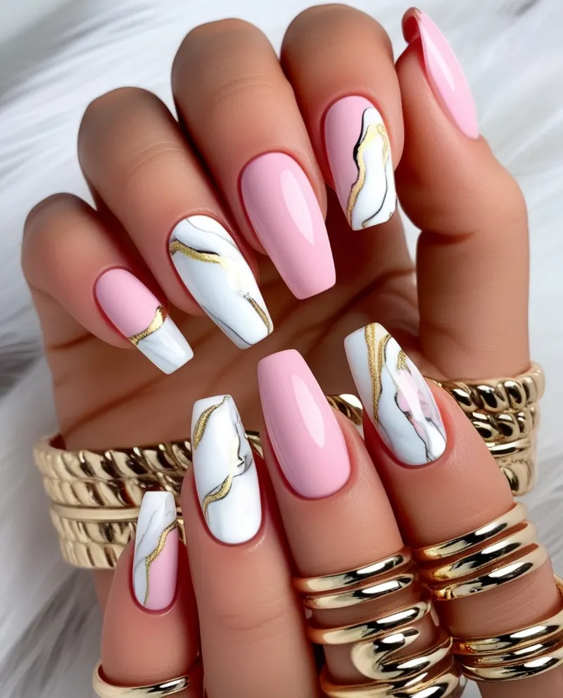 Elegant pink nails with marble patterns in white and gold.