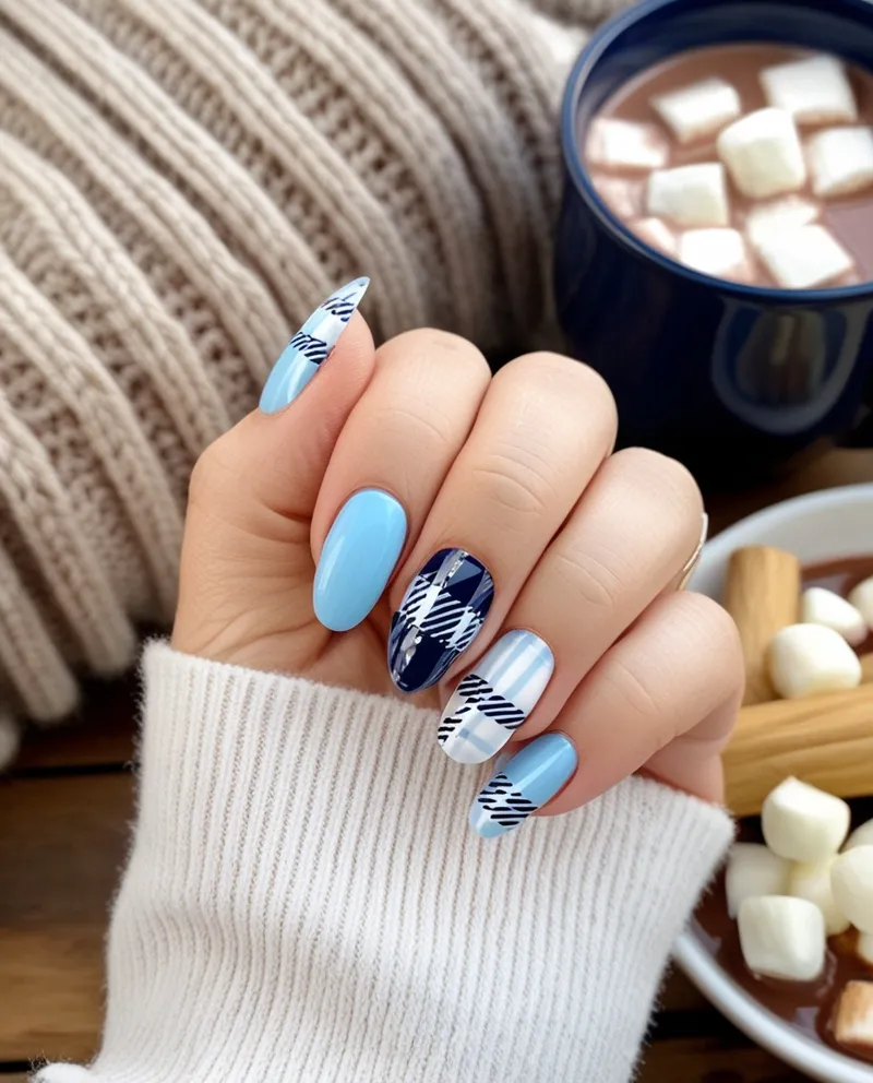 Light blue nails with white and navy plaid designs, a cozy Blue Christmas Nails idea.