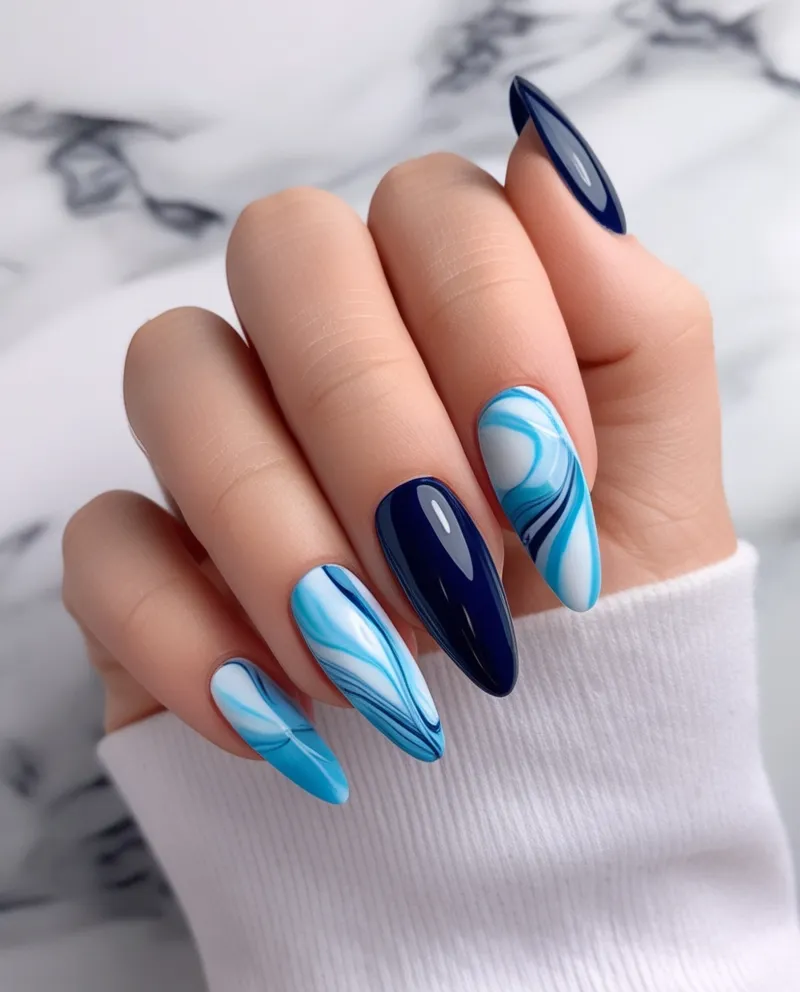 Blue marble effect nails, a classy and unique Blue Christmas Nails idea.