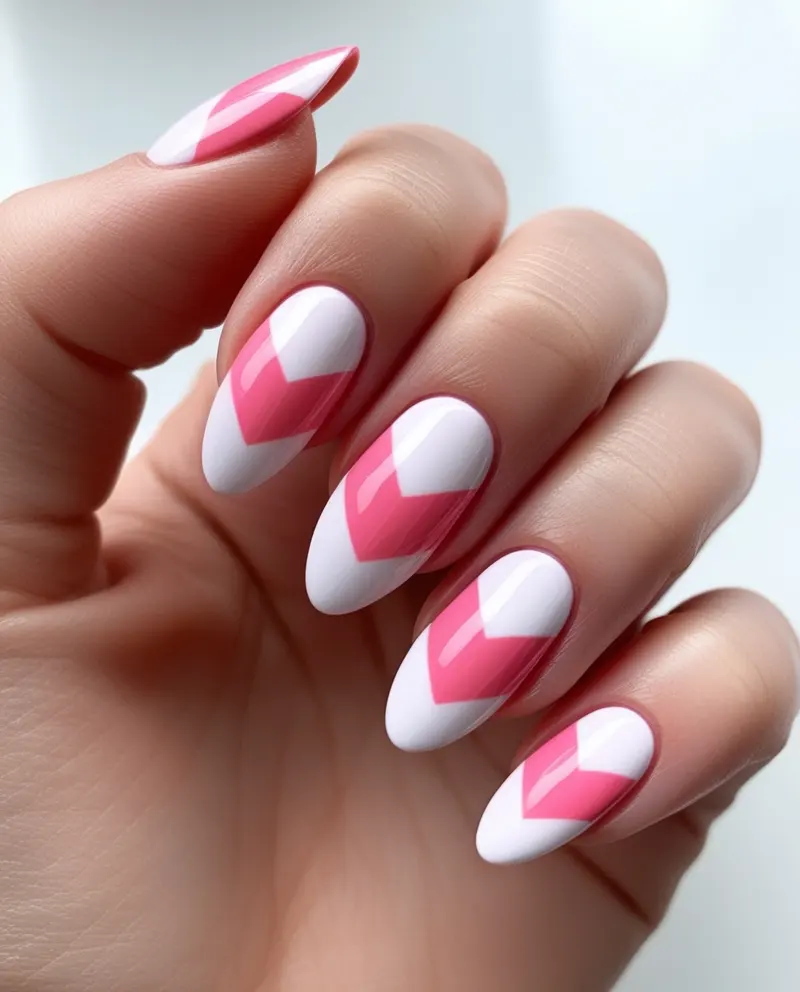 Stylish pink nails with bold chevron stripe patterns for a modern summer style.