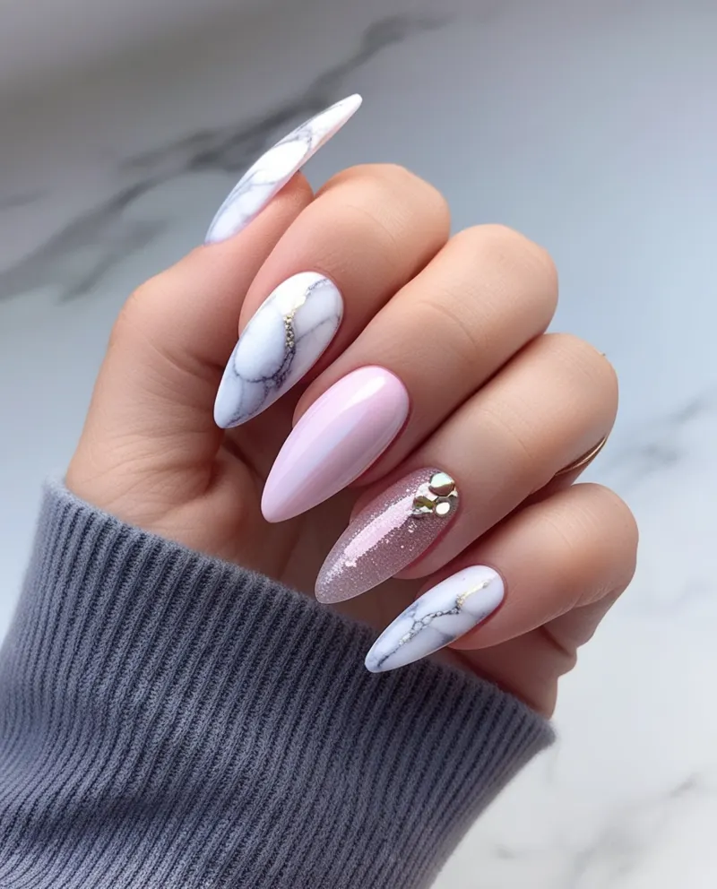 Almond-shaped nails featuring marble and glitter designs.