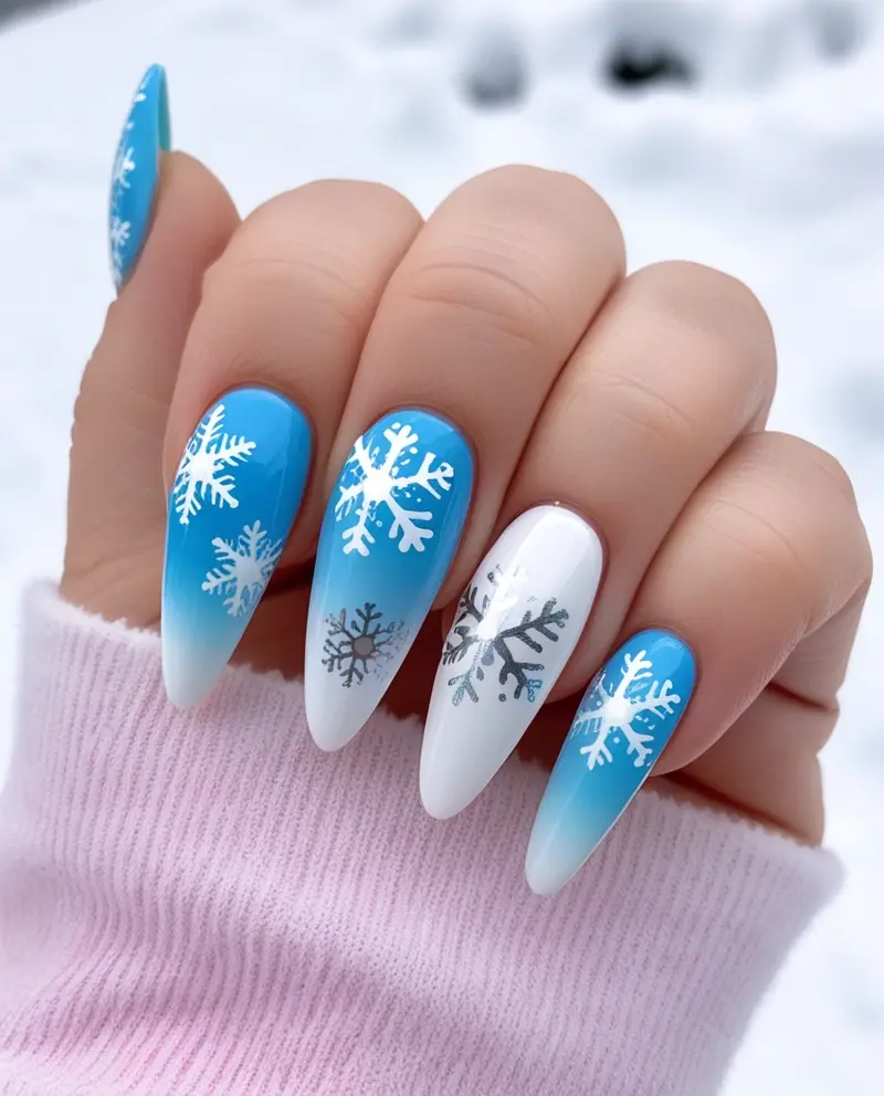 Stunning Snowflake Designs on Winter Christmas Nails in blue and white tones for a frosty winter look.