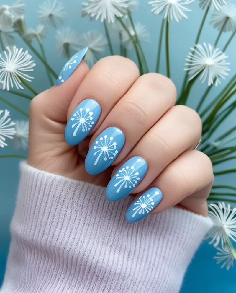 Blue nails with dandelion designs for a light and romantic touch.