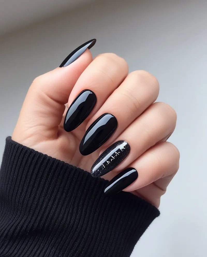 Bold black nails with glitter accents.