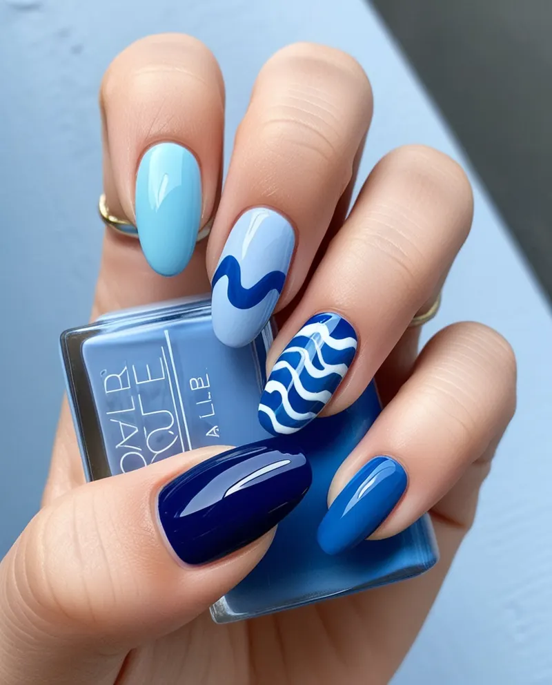 Soothing blue nails with wave and ombre patterns.