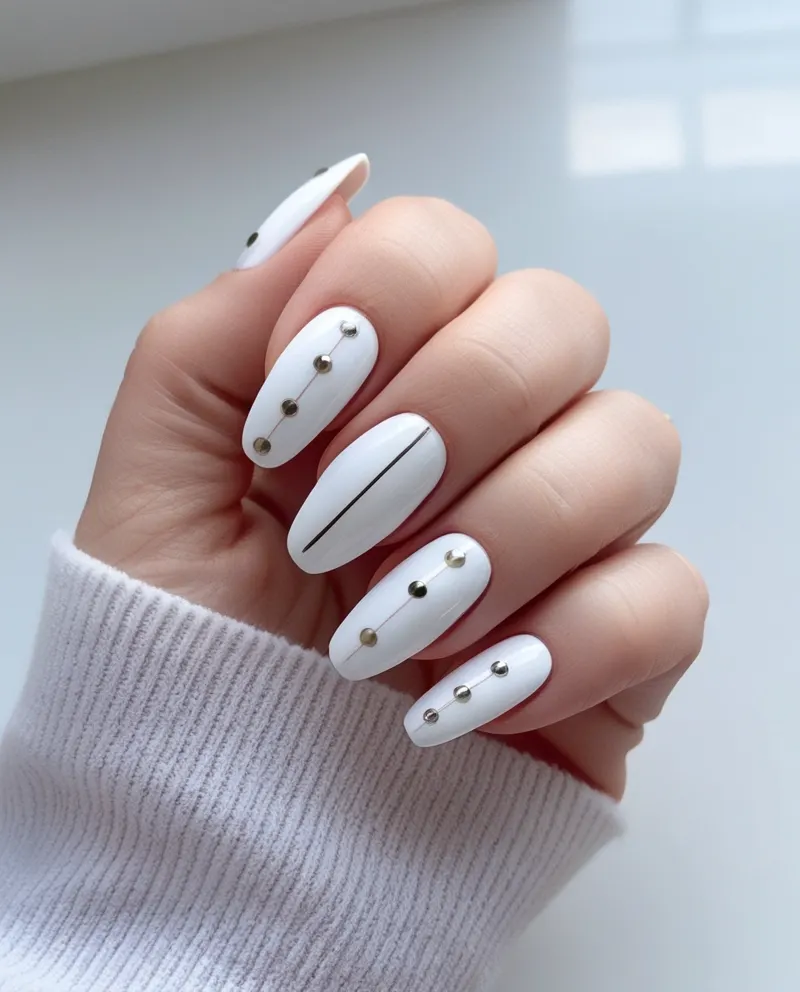 Clean white nails with simple dot and line designs.