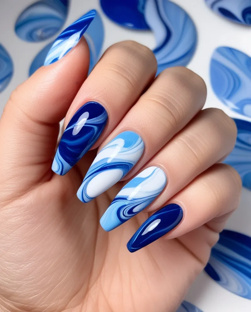 Artistic Blue Marble Nail Designs with dark and light blue swirls.