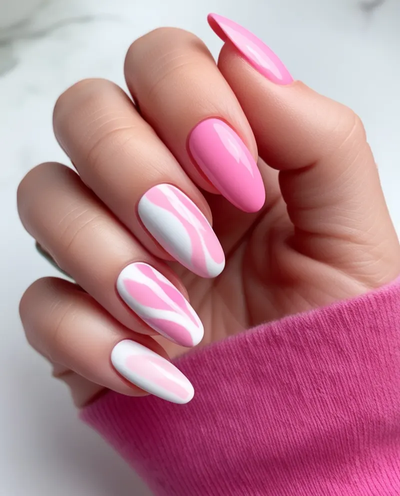 Artistic pink nails featuring soft, watercolor-like swirls and patterns.