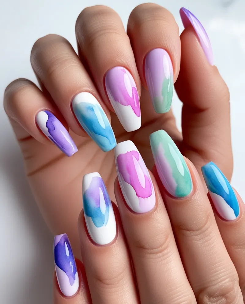 Artistic watercolor nails with blended colors for a creative look.